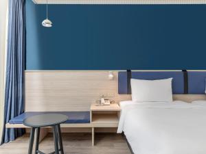 a hotel room with a bed and a table at CHECK inn Select Taipei Nangang in Taipei