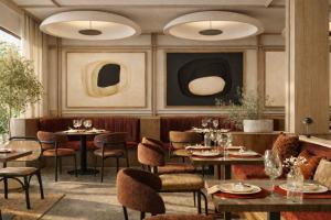 a restaurant with tables and chairs and paintings on the wall at DoubleTree by Hilton Madrid Principe de Vergara in Madrid