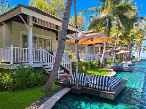 a villa with a swimming pool in front of a house at Rest Detail Hotel Hua Hin in Hua Hin