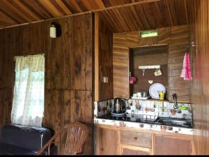 a kitchen with wooden walls and a counter with a sink at Rimaaia farm house in Lāitlyngkot
