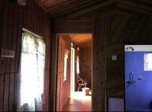 a hallway of a house with a blue refrigerator at Rimaaia farm house in Lāitlyngkot