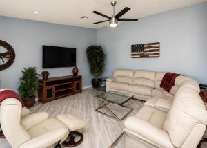 a living room with white couches and a flat screen tv at RIVERFRONT RUBY RED HOME WITH PRIVATE DOCK & View in Bullhead City