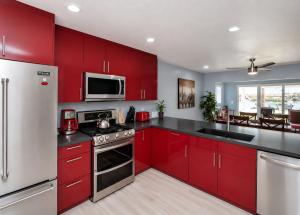 a kitchen with red cabinets and stainless steel appliances at RIVERFRONT RUBY RED HOME WITH PRIVATE DOCK & View in Bullhead City