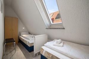 a attic room with two beds and a window at Ferienwohnung-mit-Balkon in Rechlin