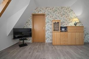 a living room with a flat screen tv and a dresser at Ferienwohnung-mit-Balkon in Rechlin