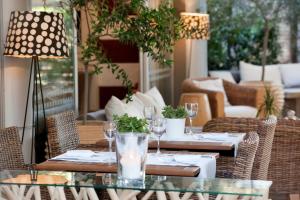 a patio with tables and chairs with wine glasses at Sea View Hotel in Athens