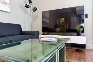 a living room with a couch and a glass table at Danforth Hotel in Toronto