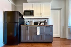 a kitchen with a black refrigerator and a microwave at Danforth Hotel in Toronto