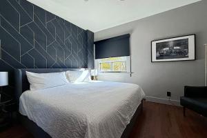 a bedroom with a large bed and a window at Danforth Hotel in Toronto