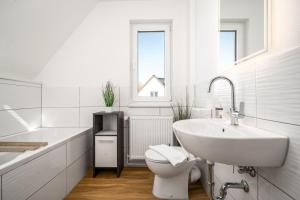a white bathroom with a sink and a toilet at Ferienwohung-Liv-OG in Rechlin +35 photos