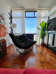 a living room with a chair and a large window at Departamento chic centro 2 habitaciones in Mendoza