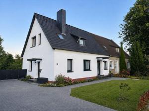 a white house with a black roof at Ferienwohung-Liv-OG in Rechlin