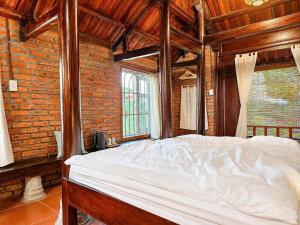 a bedroom with a white bed in a brick wall at La Belle Saison Homestay Huế in Hue +35 photos