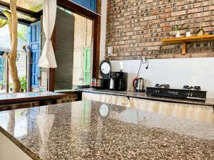 a kitchen with a counter top and a brick wall at La Belle Saison Homestay Huế in Hue