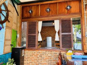 a kitchen with wooden shutters on a brick building at La Belle Saison Homestay Huế in Hue
