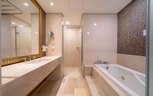 a bathroom with two sinks and a tub and a shower at BS Centum hotel in Busan +82 photos
