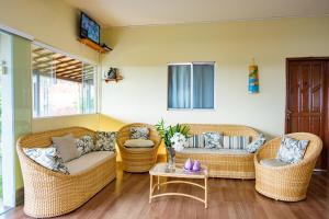 a living room with wicker chairs and a table at Pousada Bela Vista in Conde