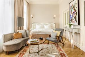 una camera da letto con un letto, un divano e un tavolo di Hotel Sans Souci Wien a Vienna