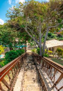 a wooden bridge with a tree on it at Pousada Bela Vista in Conde