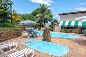 a patio with chairs and a swimming pool at Pousada Bela Vista in Conde