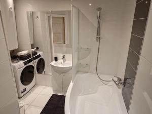 a white bathroom with a washing machine and a sink at Mirdzas Ķempes iela 14 in Liepāja +2 photos