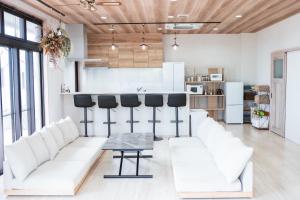 a living room with white couches and a table at guest house ALO in Miyako-jima +29 photos