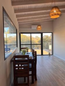 a dining room with a table and chairs and windows at Monteolivos Home & Suites in El Rincón