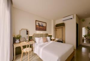 a bedroom with a white bed and a desk and a chair at LoverA Signature Hotel in Ho Chi Minh City