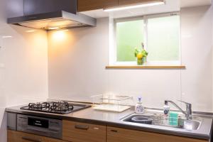 a kitchen with a sink and a stove and a window at S-villa Nasu 4th in Nasu