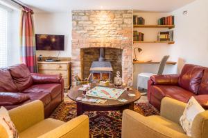 a living room with couches and a fireplace at Old Swan in Witney