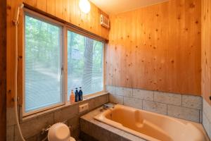 a bathroom with a tub and a window at S-villa Nasu 4th in Nasu