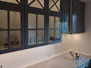 a kitchen with black cabinets and a counter with dishes at Mirdzas Ķempes iela 14 in Liepāja