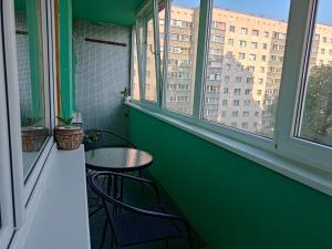 a green balcony with two chairs and a table at Mirdzas Ķempes iela 14 in Liepāja