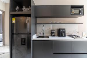 a kitchen with a stainless steel refrigerator and appliances at Hotel Colores Estadio in Medellín
