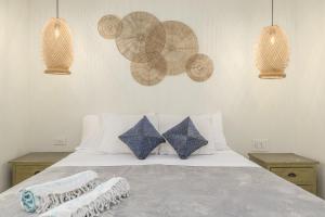 a bedroom with a white bed with blue pillows at NEW RENOVATION - Beachside Two-Bedroom Suite in Savaneta