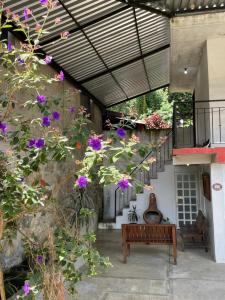 a patio with a bench and some flowers at Arca de Noé in Xaltepec
