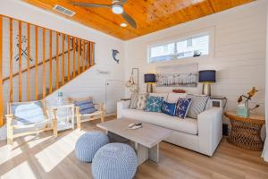 a living room with a couch and a table at Salty Waves | Beach Cottage, Walk to Beach, Pool, Fenced Yard & Grill in Port Aransas