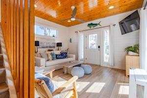a living room with a couch and a table at Salty Waves | Beach Cottage, Walk to Beach, Pool, Fenced Yard & Grill in Port Aransas