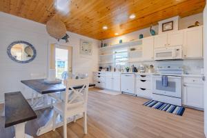 a kitchen with white cabinets and a wooden ceiling at Salty Waves | Beach Cottage, Walk to Beach, Pool, Fenced Yard & Grill in Port Aransas