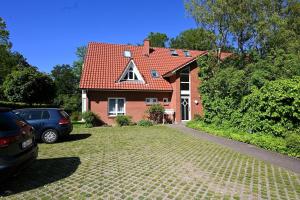 a red brick house with a car parked in the driveway at Kunst-kuesst-Kueste in Hohwacht
