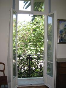 an open glass door with a view of a tree at Résidence La Villa Léonie in Nice