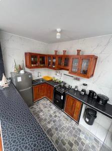 a kitchen with wooden cabinets and black appliances at Mihahi Beach Mancora in Máncora