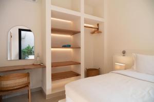 a bedroom with a white bed and a mirror at Tiga Villas in Kuta Lombok