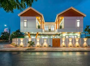 a large white house with a fence at Cloud Rose Villa Hoi An in Danang
