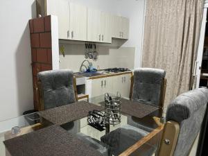a kitchen with a glass table and chairs and a counter at Tayra Living Suites in Mocoa