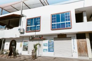 a white building with windows and a garage at PELICAN TOURS in Puerto Baquerizo Moreno