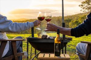 two people holding glasses of wine at a picnic table at Byadbo in Tuncurry +25 photos
