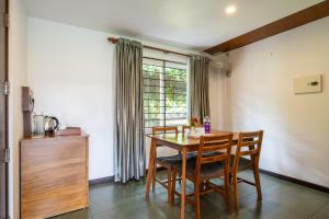 a dining room with a table and chairs and a window at Falcon Crest in Vagamon