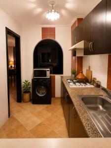a kitchen with a washer and a sink and a stove at Résidence Tarifa in Mrarech