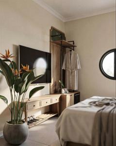 a bedroom with a dresser with a tv and a plant at LoverA Signature Hotel in Ho Chi Minh City